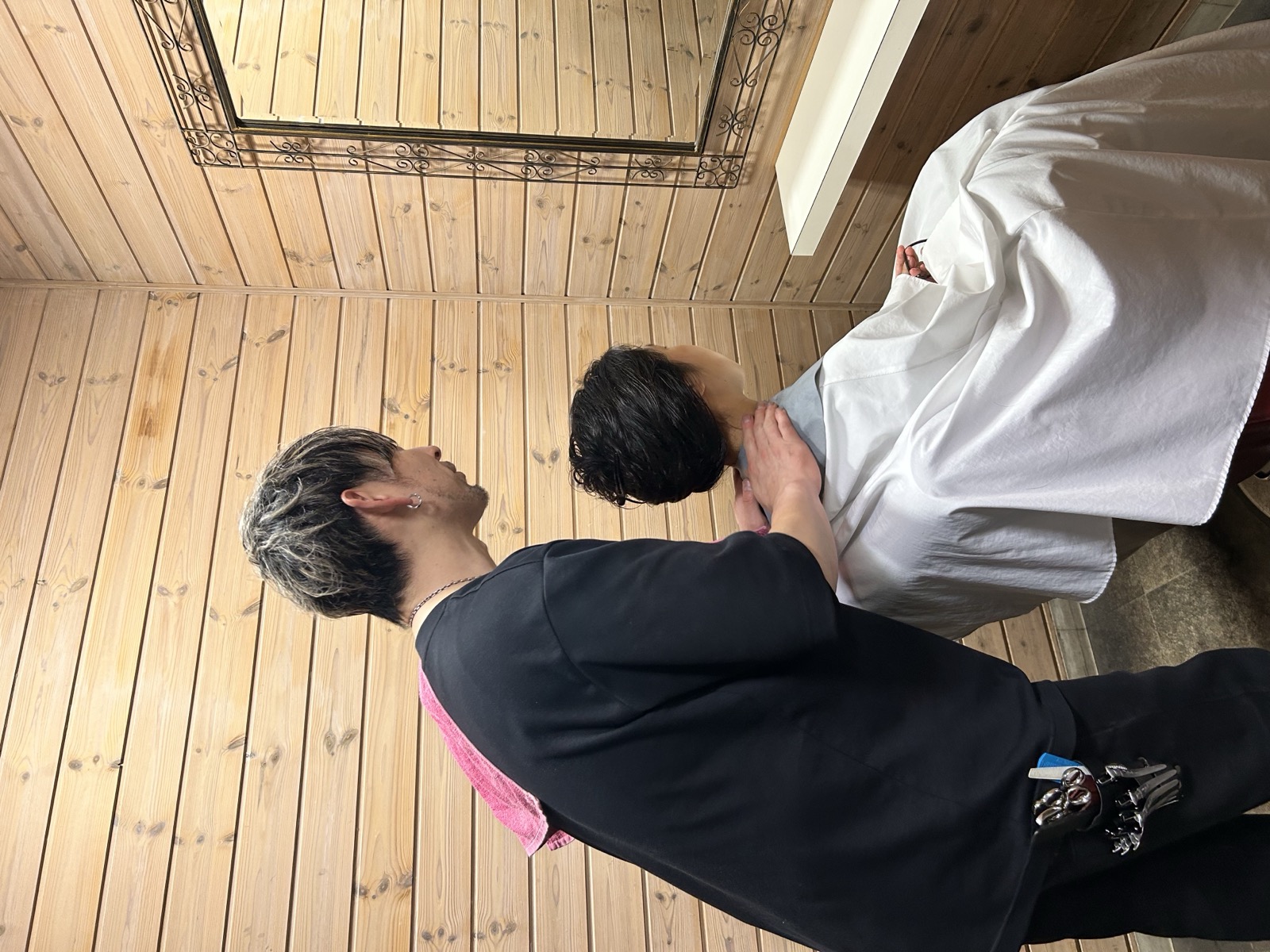 鏡の前で仕上がりを確認する施術風景